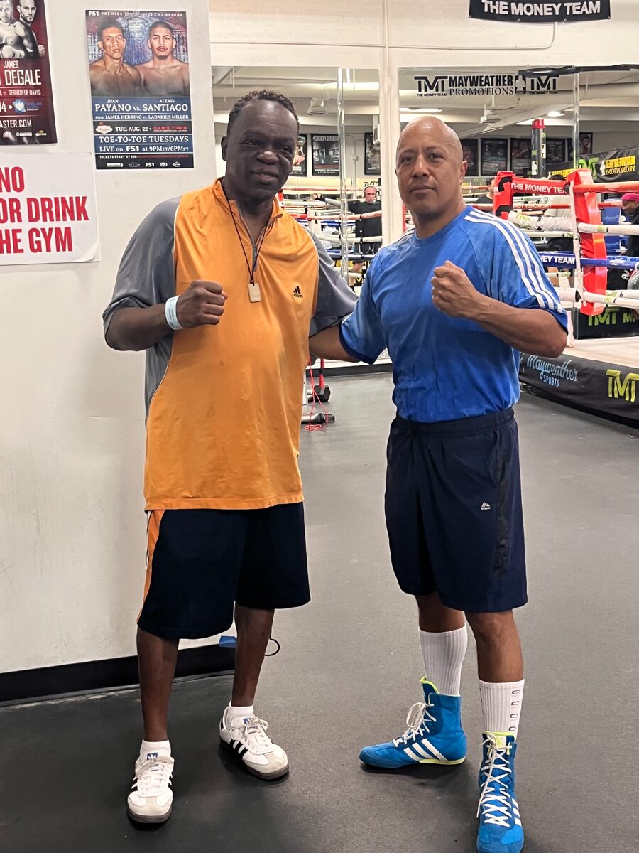 Coach Wacho with a boxing mentor inside the gym