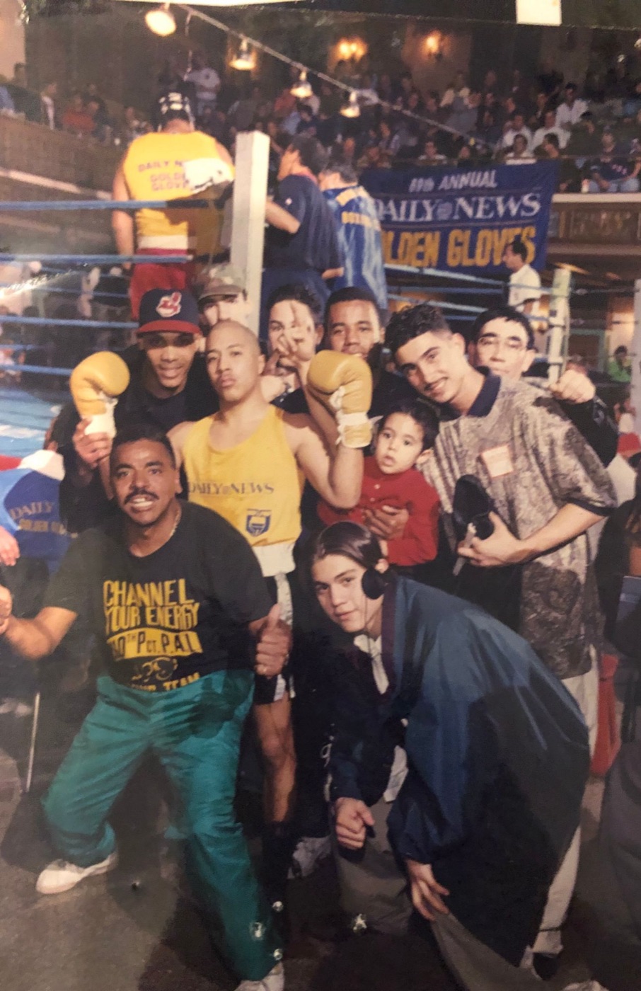 Boxer in a Daily News tank top celebrating with his team ringside at the Daily News Golden Gloves