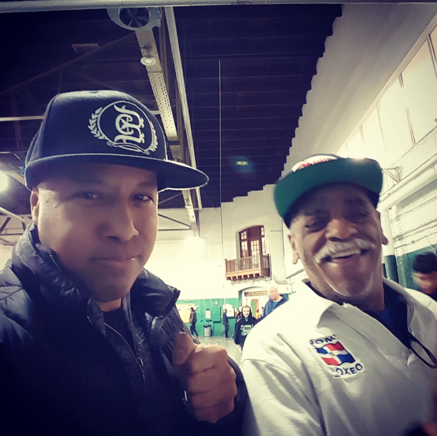 Two men in a boxing gym, one wearing a ChampionBreed cap